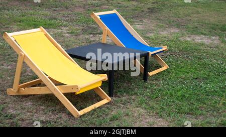 Two Miniature Deckchairs On Sunny Beach  . Chairs on the tropical beach near sea, Thailand. Holidays Background.sunbath seats and colorful in Prachubk Stock Photo