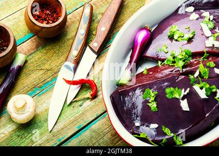 Piece of raw beef liver on the kitchen table Stock Photo