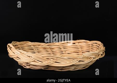 A beautiful rattan basket on black background. Stock Photo