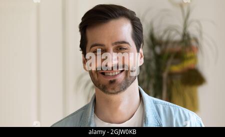 Headshot portrait of millennial guy posing smiling on camera Stock Photo