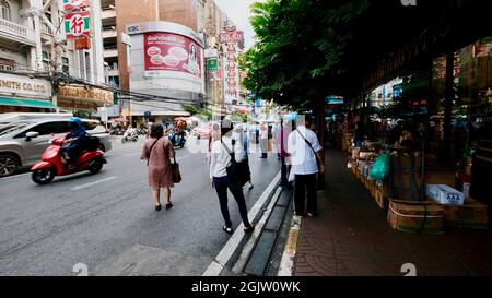 People Waiting for a Bus on Yaowarat Road Samphanthawong District is the main artery of Bangkok's Chinatown. covid era, pandemic era, lockdown era Stock Photo