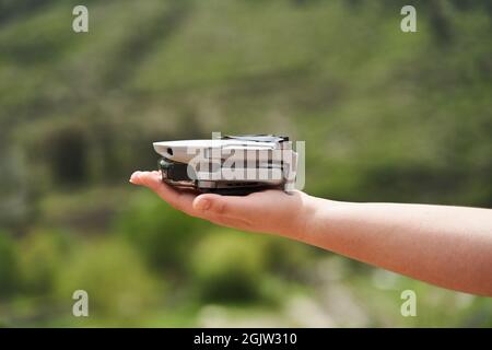 Modern small compact quadcopter in a girl's hand. Launching a drone from your hand Stock Photo
