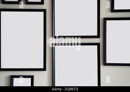 Different size framed photos hanging on the gray wall. Mockup. Stock Photo
