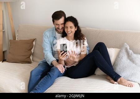Couple relaxing indoor using smartphone enjoy internet entertainment make videocall Stock Photo