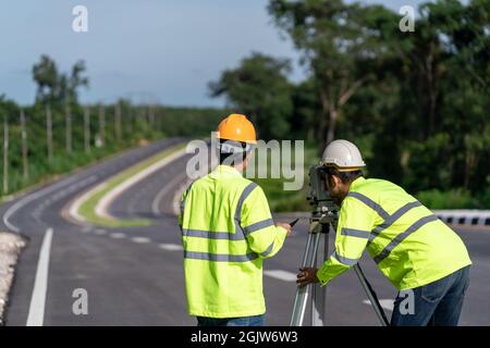 Teamwork of surveyor engineers with equipment on road construction site, Civil Engineers, Surveyor equipment. Stock Photo