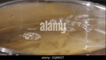 penne pasta in saucepan with boiling water, wide photo Stock Photo
