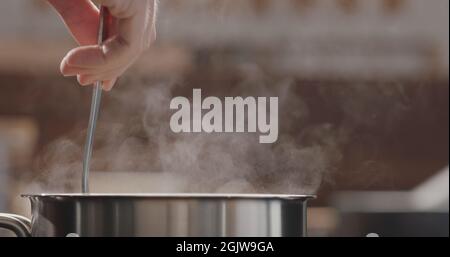 penne pasta stir in saucepan with boiling water, wide photo Stock Photo