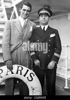 CARY GRANT in 1936 poses with Crew Member of Ocean Liner SS PARIS of the French Line on crossing from Le Havre to New York Stock Photo