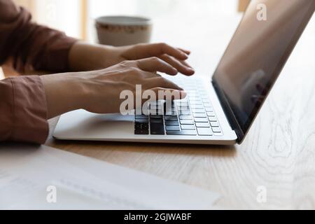 Close up of young woman teleworker hands typing on laptop Stock Photo