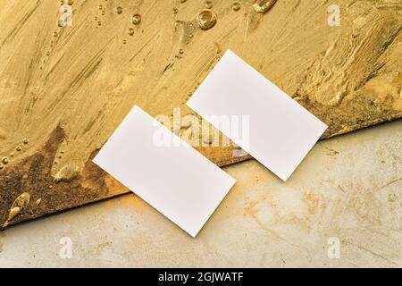 Two business cards for art director on the background from gold painting and a workplace for creativity. Gold strokes, abstraction Stock Photo