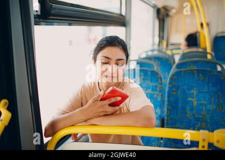 Indian Woman ride in public transport bus using mobile phone Stock Photo