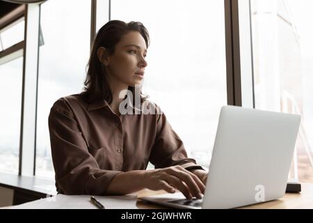 Pensive female employee work on computer make decision Stock Photo