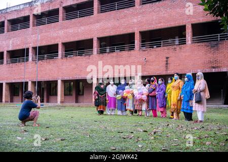 Non Exclusive: DHAKA, BANGLADESH - SEPTEMBER 11: A student of class three is seen taking photographs of some of the teachers and guardians of Kolotan Stock Photo