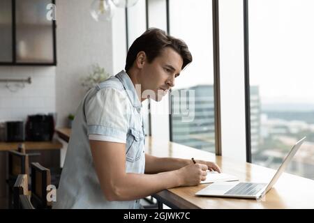 Young Caucasian male write using laptop gadget Stock Photo