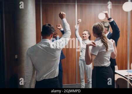 Businessman and businesswoman team doing warming up exercises before office meeting. Business healthy successful people group man and woman after conference discussion with boss. Stock Photo