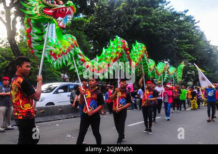 The youths parading a liong or dragon while participating in the Cap Go Meh carnival in Jakarta. Stock Photo