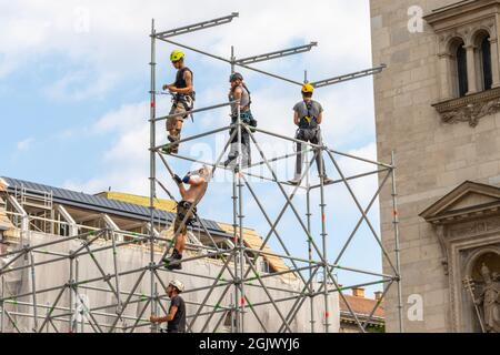 BUDAPEST, HUNGARY - AUGUST 19, 2021: Team of construction workers on a scaffold. Men working at scaffolding at construction site with metal Stock Photo