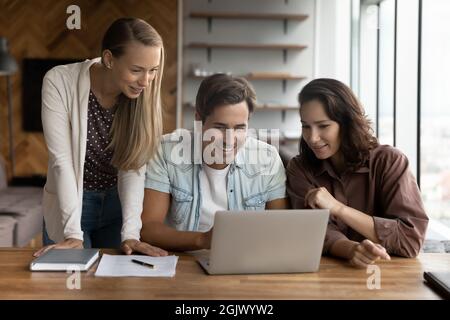 Smiling diverse colleagues work together on laptop Stock Photo