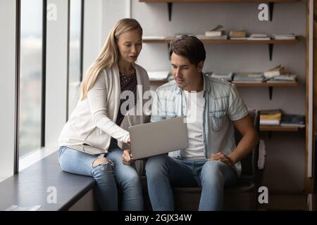Diverse employees brainstorm work on laptop together Stock Photo