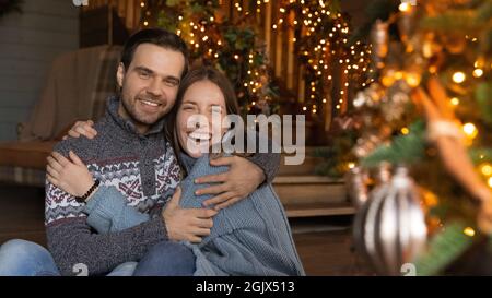 Portrait of happy emotional young affectionate family couple celebrating Christmas. Stock Photo