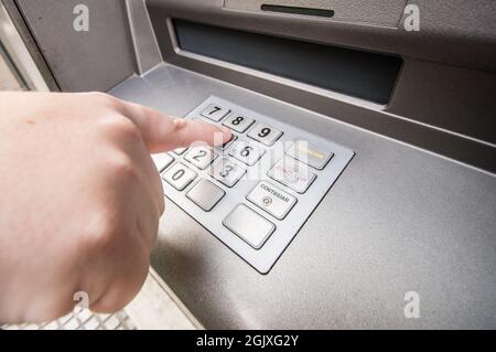 A woman finger pressing password number on ATM machine Stock Photo