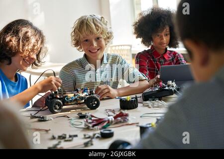 Happy schoolboy with group of classmates on science lab work at school. Stock Photo