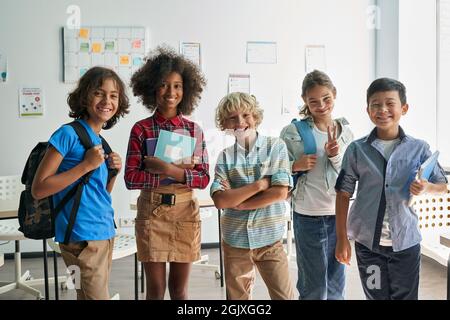 Portrait of happy cheerful smiling diverse schoolchildren in classroom. Stock Photo