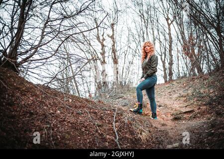 Portrait of young woman with curly hair standing on the hill. Copy space Stock Photo