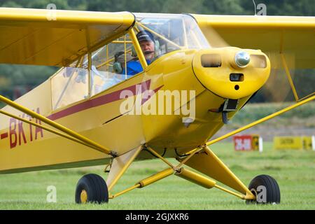 Piper Pa-18 Super Cub light aircraft from the 1950s seen taxying at a grass airfield in the UK Stock Photo