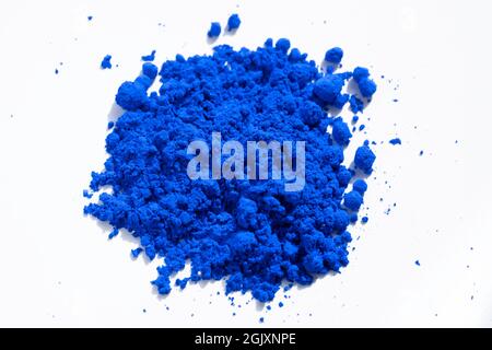 Close up of a portion of blue pigment isolated on white seen from above. The pigment will be mixed with linseed oil to make oil paint Stock Photo