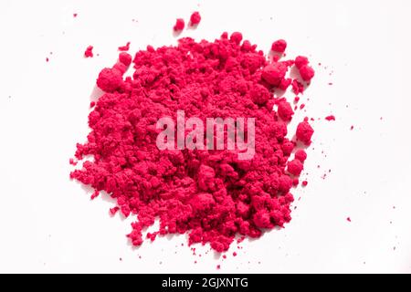 Close up of a portion of red pigment isolated on white. The pigment can be used as a base for makeup or mixed with linseed oil to make oil paint Stock Photo