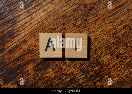 AI abbreviation for Artificial Intelligence, in wooden alphabet letters isolated on textured wood Stock Photo