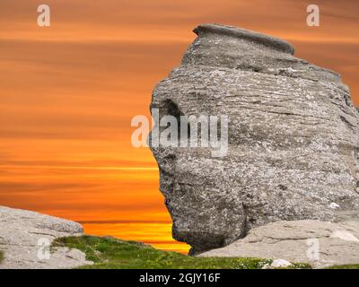 The natural rock formation in the Bucegi Natural Park which is in the Bucegi Mountains of Romania called The Sphinx (Sfinxul) at sunset Stock Photo