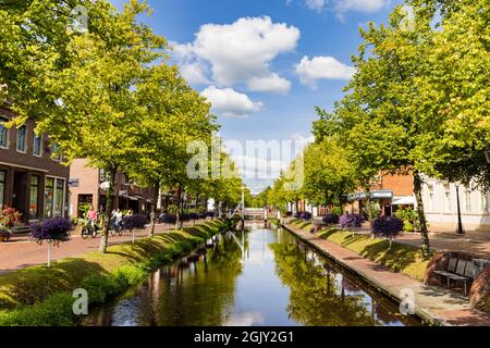 Papenburg, Germany - August 24, 2021: Colorful old village centre of Papenburg along river Ems with canals, little brdiges and ancient ships in Lower Saxony in Germany