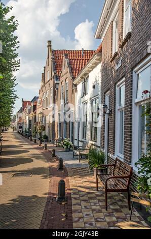 Hasselt, The Netherlands, August 11, 2021: slightly curved row of brick and plaster facades on Heerengracht canal in the old town Stock Photo