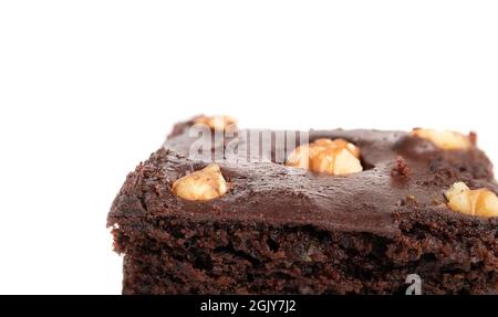 Vegan brownie closeup with chocolate icing and nuts. Partial perspective view of delicious fudgy dark and moist chocolate brownie. Selective focus. Is Stock Photo