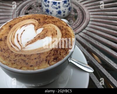 Cappucino on garden table / cafe Stock Photo