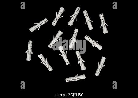 Grey plastic dowels isolated on black background. Dowels. Wall plugs isolated on a white background. Screw anchor or dowel Stock Photo