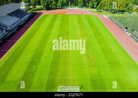 Aerial view of green football field. New public soccer stadium empty to be used for soccer game outdoors from above. Beautiful soccer playground as background texture concept Stock Photo