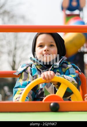 POZNAN, POLAND - Mar 25, 2018: A four years old boy sitting in a spring car at a playground Stock Photo
