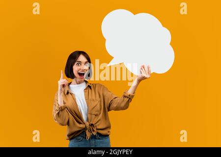 Wow idea concept. Surprised woman holding blank speech bubble and finger up, space with mockup for ad design Stock Photo
