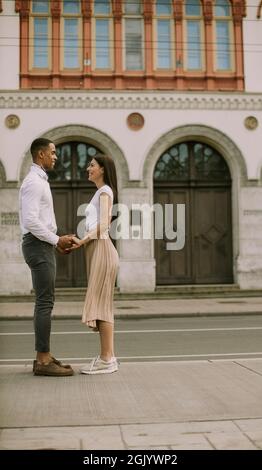 Handsome young multiethnic couple standing on the street Stock Photo