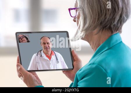 Patient with tablet, having remote consultation with doctor. Stock Photo