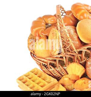 Sweet pastries, bread and flour products in a wicker basket isolated on white background. Stock Photo