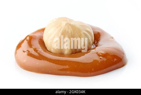 whole hazelnut in melted caramel drop macro isolated on white background Stock Photo