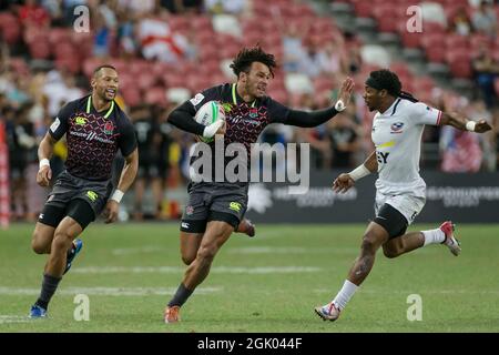 SINGAPORE-APRIL 14: Ryan Olowofela of England 7s Team (middle/blue) in action against Carlin Isles of USA 7s team (white) during the Bronze medal match of HSBC World Rugby Singapore Sevens on April 14, 2019 at National Stadium in Singapore Stock Photo