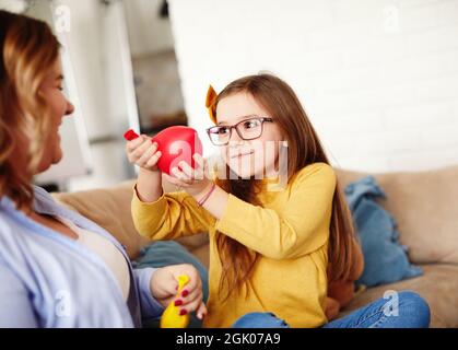 child daughter motherballoon blowing family happy playing kid childhood Stock Photo