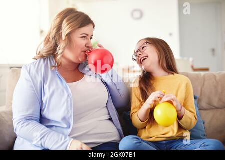 child daughter motherballoon blowing family happy playing kid childhood Stock Photo