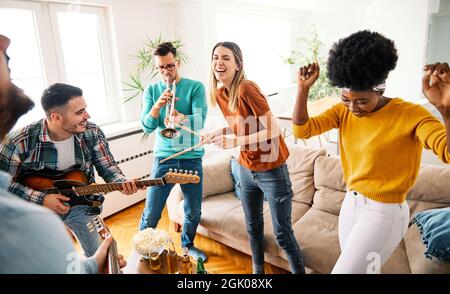 girl party dancing drinking beer bottle fun friend band instruments guitar play Stock Photo