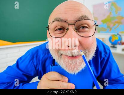 Back to school. Funny teacher preparing lesson. College lecturer in glasses with pencil. Learning and education. Stock Photo